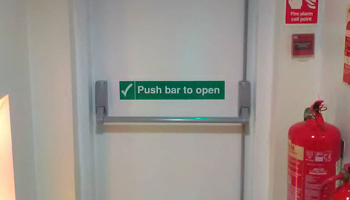Fire door with push bar to open sign