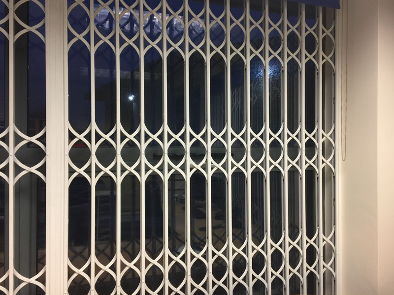 Closed white security grills over a window